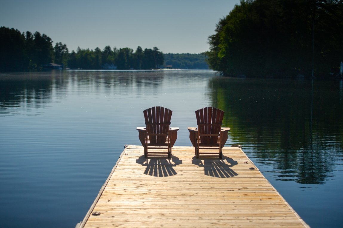 Chairs on a patio on side of lake