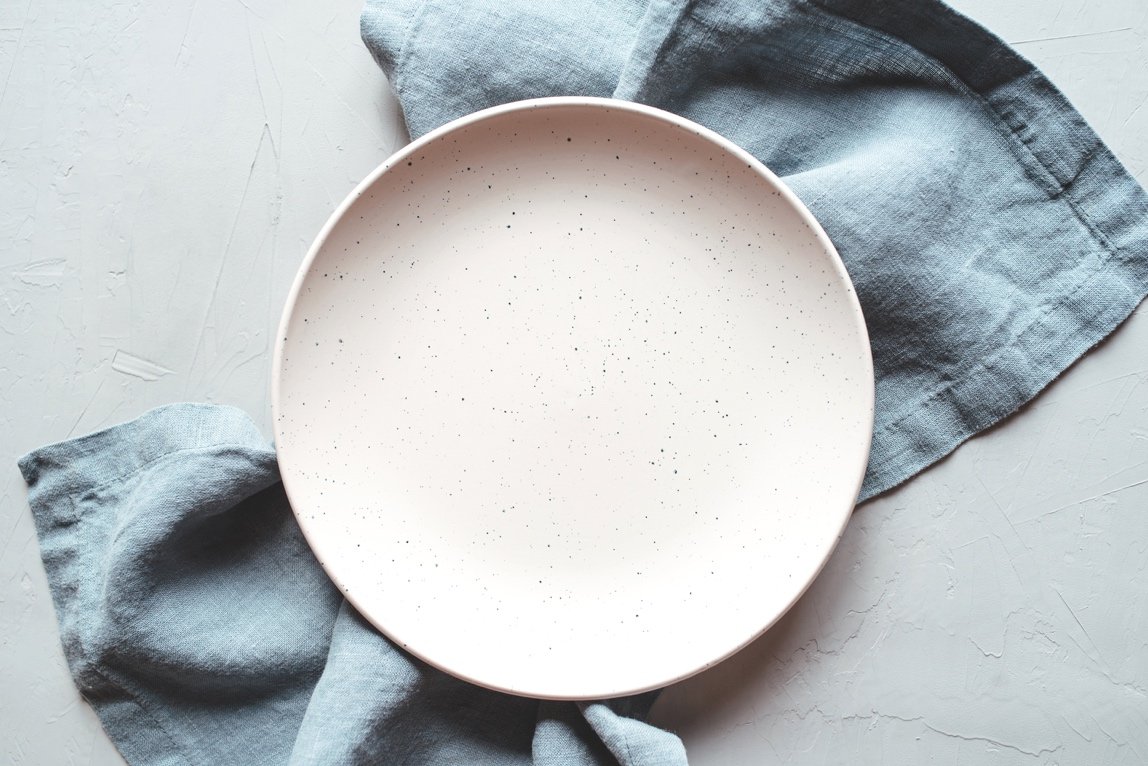 Empty ceramic plate on gray napkin