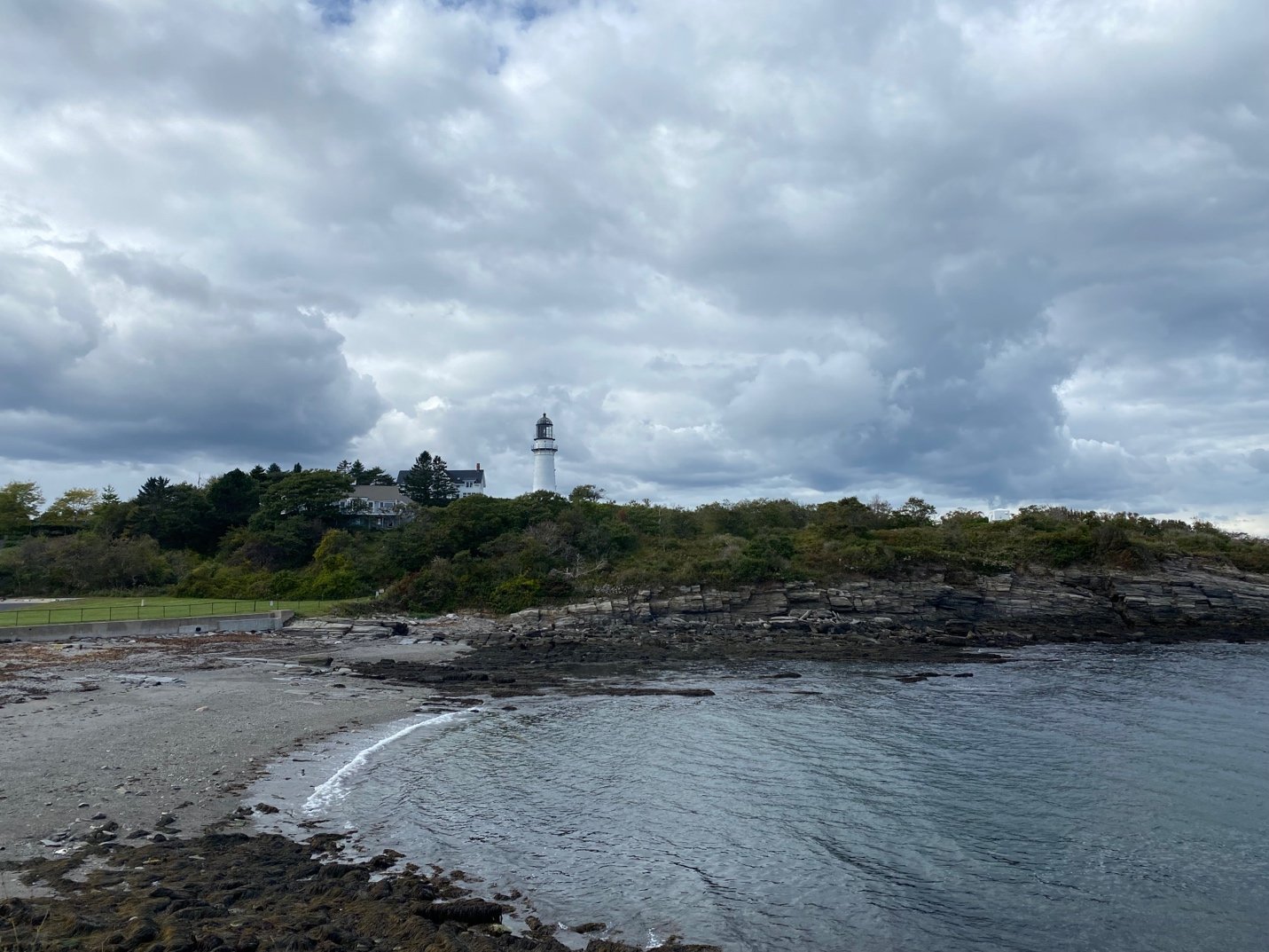 A beach with a lighthouse and a body of water

Description automatically generated