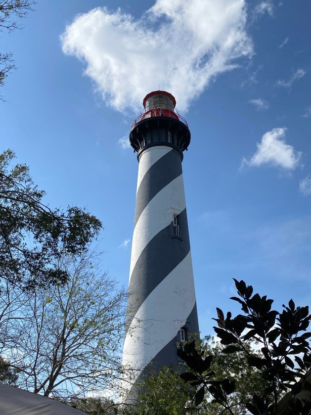 A black and white striped lighthouse with St. Augustine Light in the background Description automatically generated